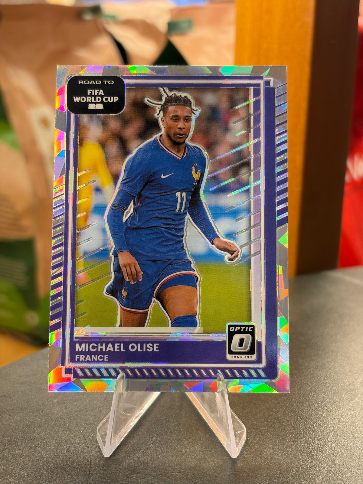 Michael Olise — Panini Donruss Optic Road to FIFA World Cup 2026 (No. 140), paralela Cracked Ice